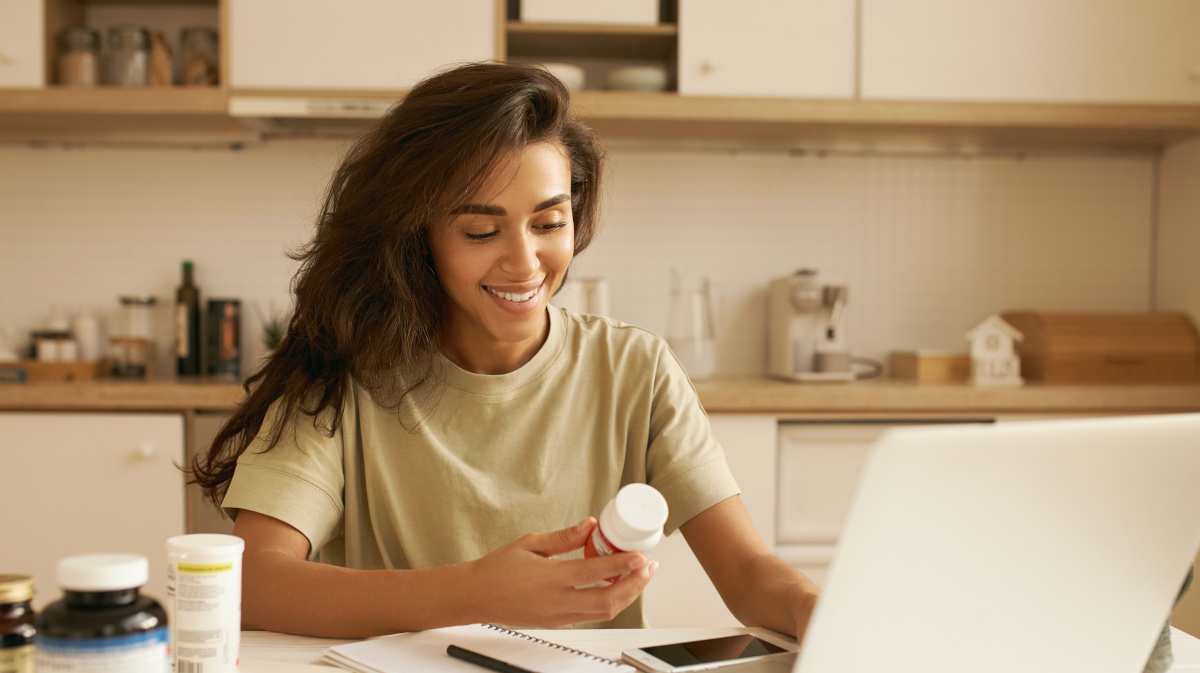 Young woman choosing a multivitamin supplement